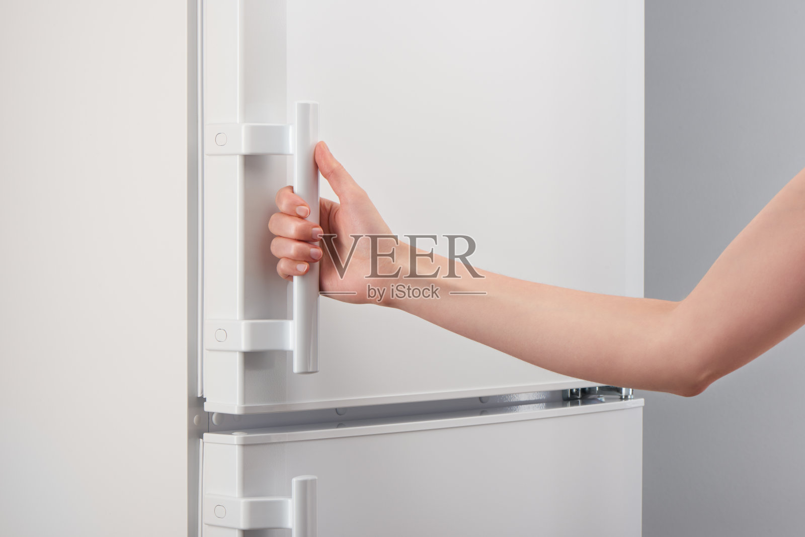 白色冰箱门的女性拉手照片摄影图片