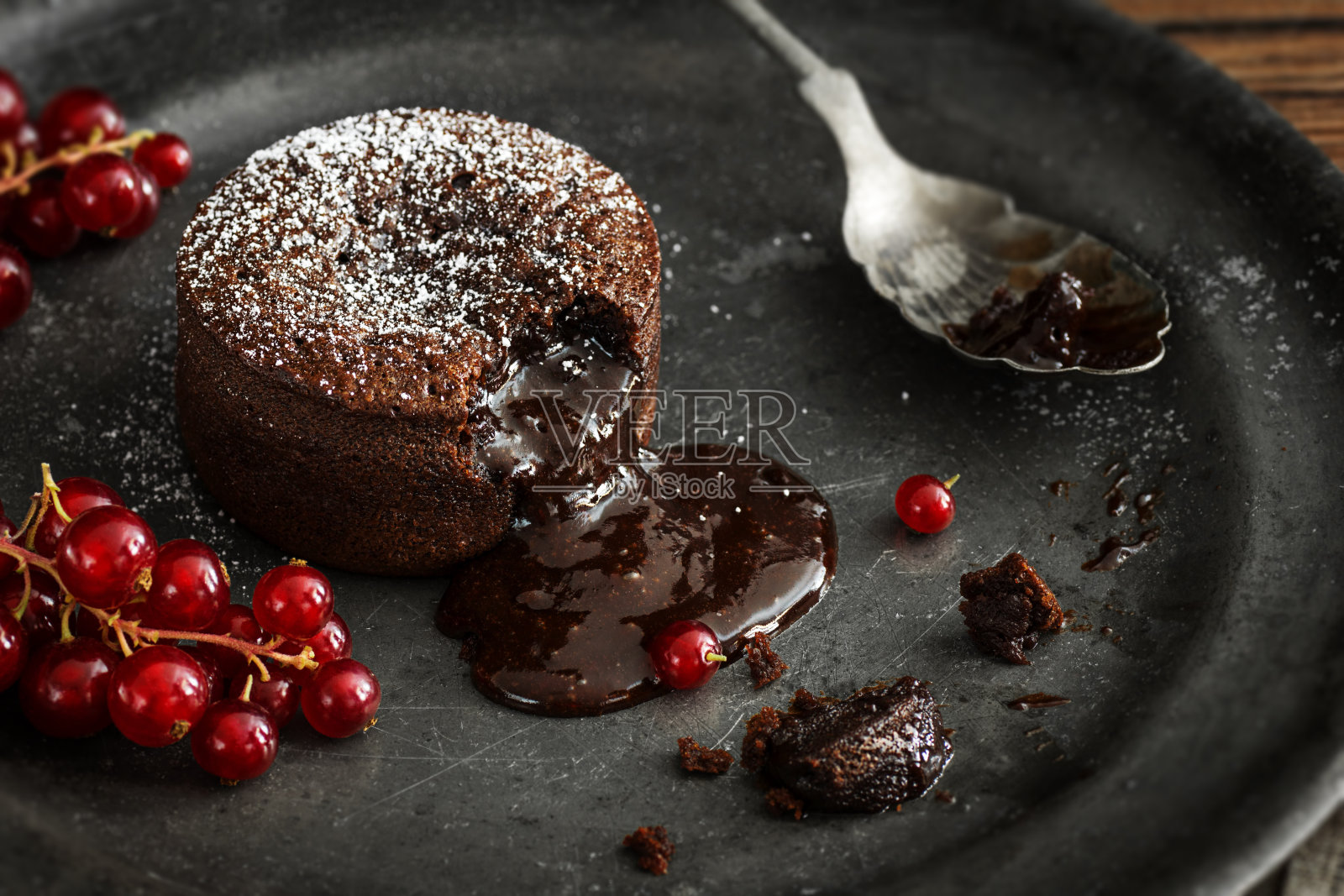热巧克力熔岩蛋糕与熔融中心和红醋栗照片摄影图片