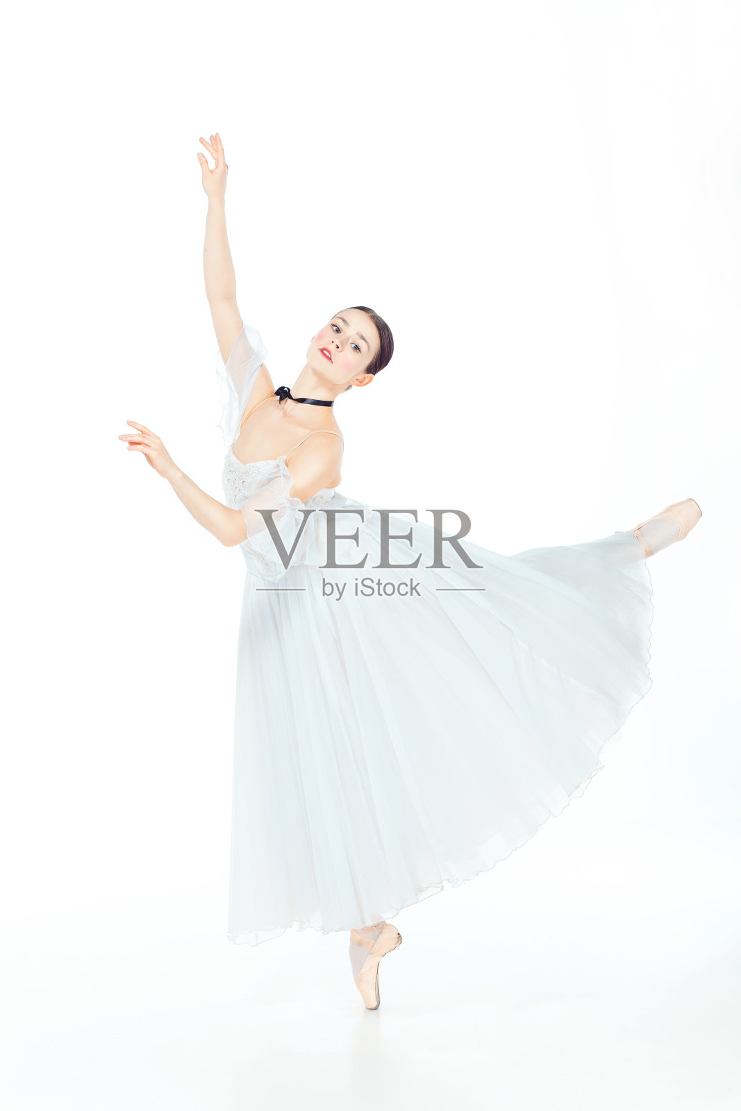 芭蕾舞者在白色的裙子在尖头鞋摆姿势，工作室背景。照片摄影图片