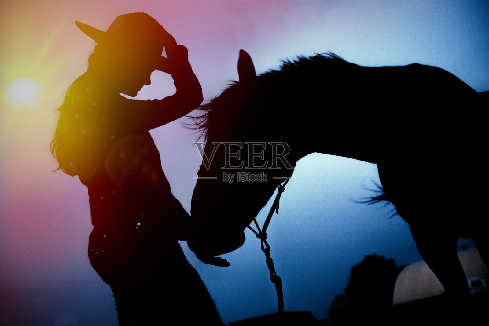 女性剪影在日落喂马照片摄影图片