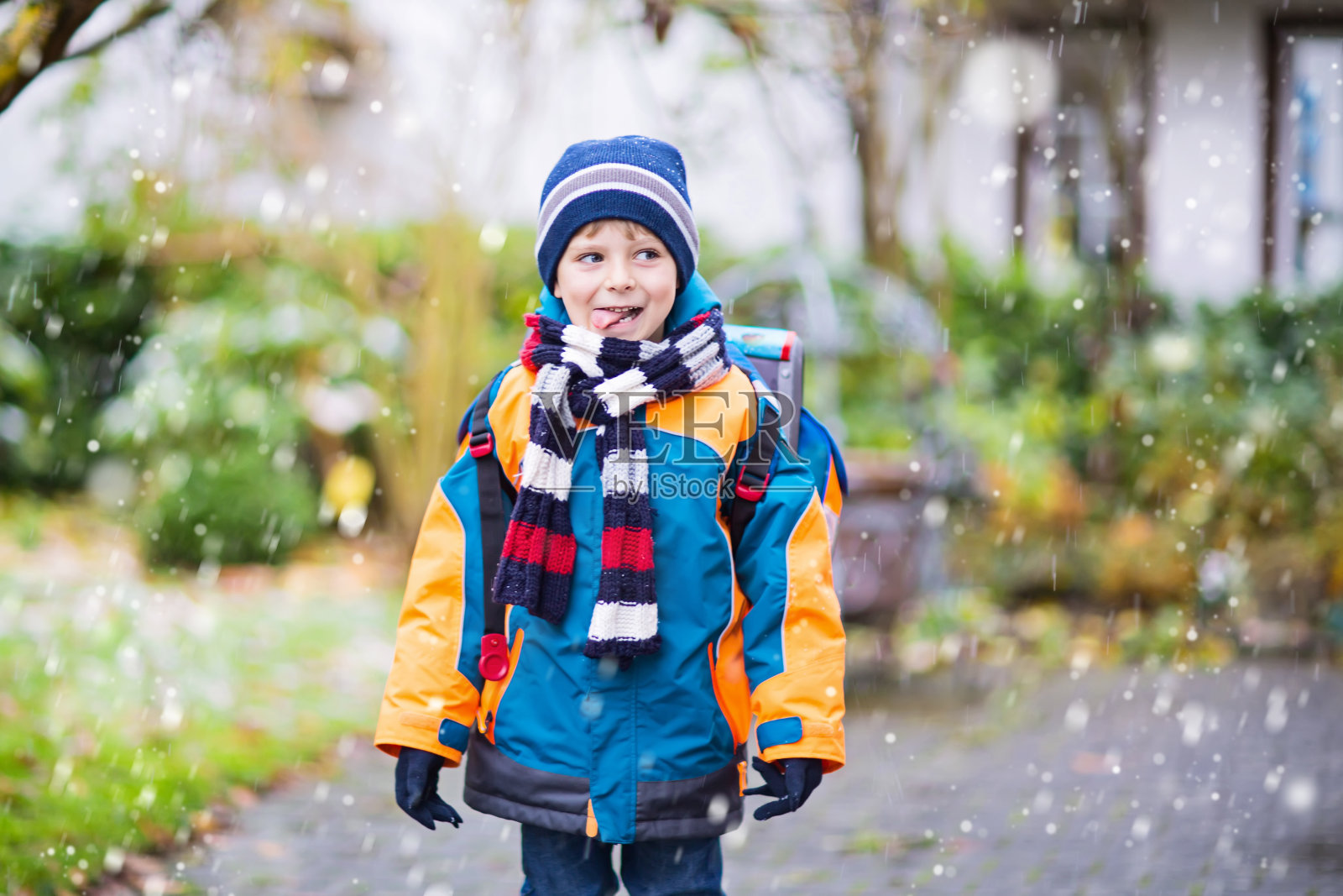 快乐的孩子男孩在冬天上学的路上照片摄影图片