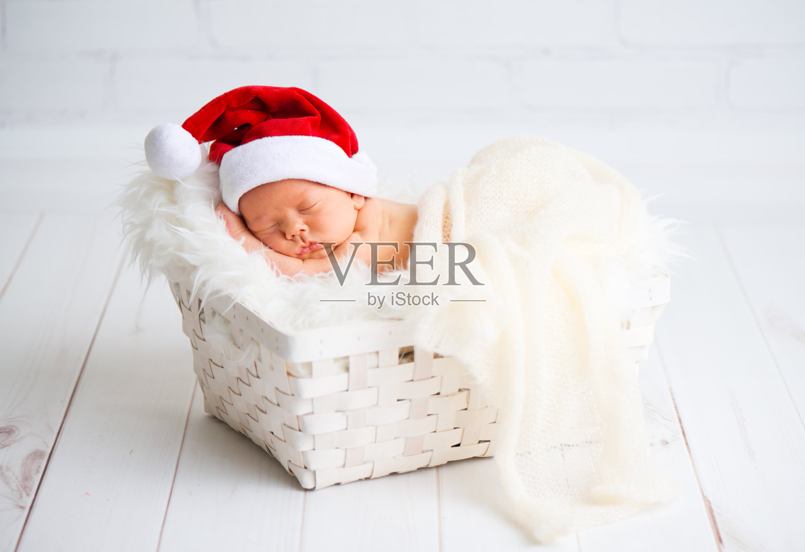 睡着的新生儿戴着圣诞老人帽照片摄影图片