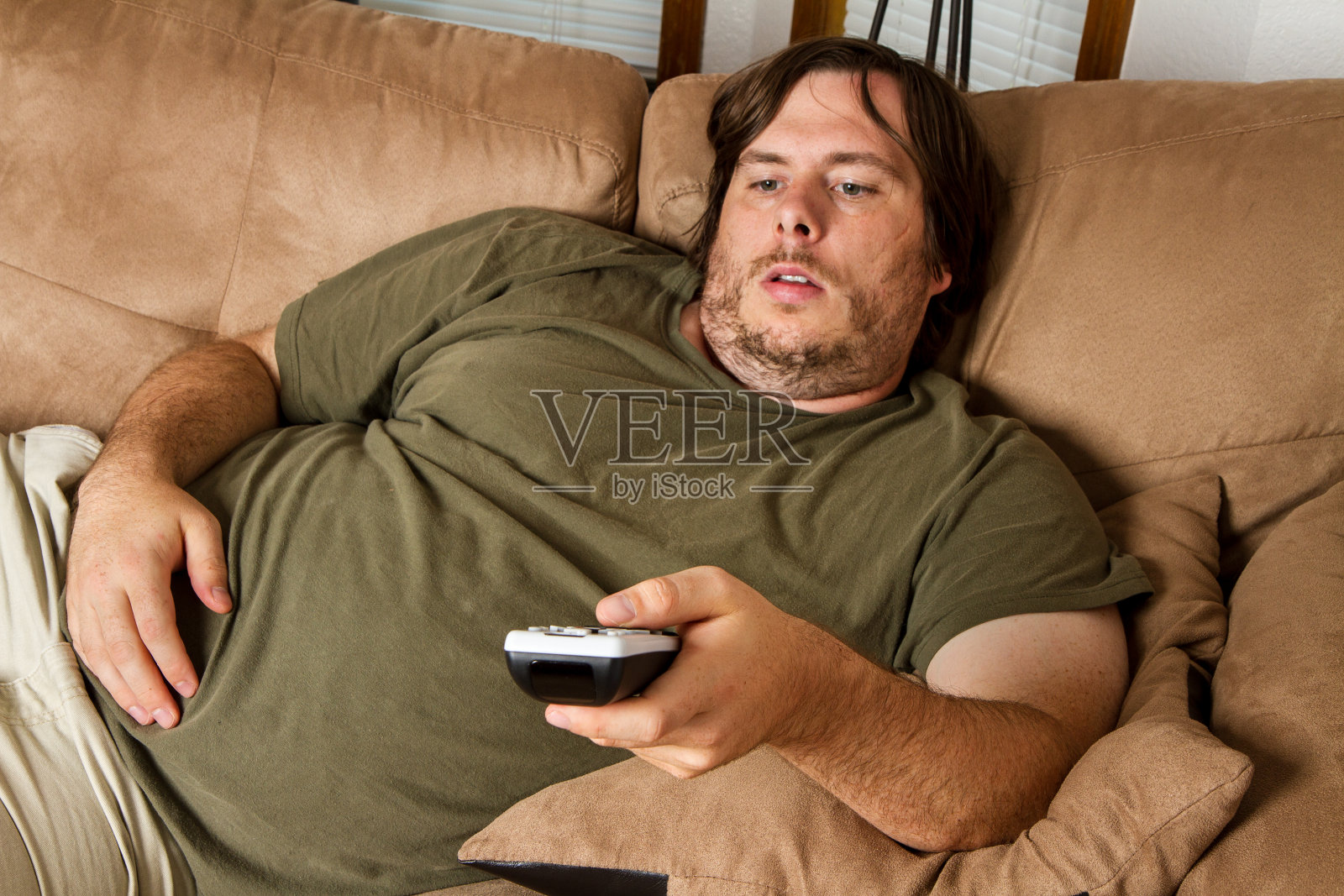 一个胖子在沙发上看电视照片摄影图片