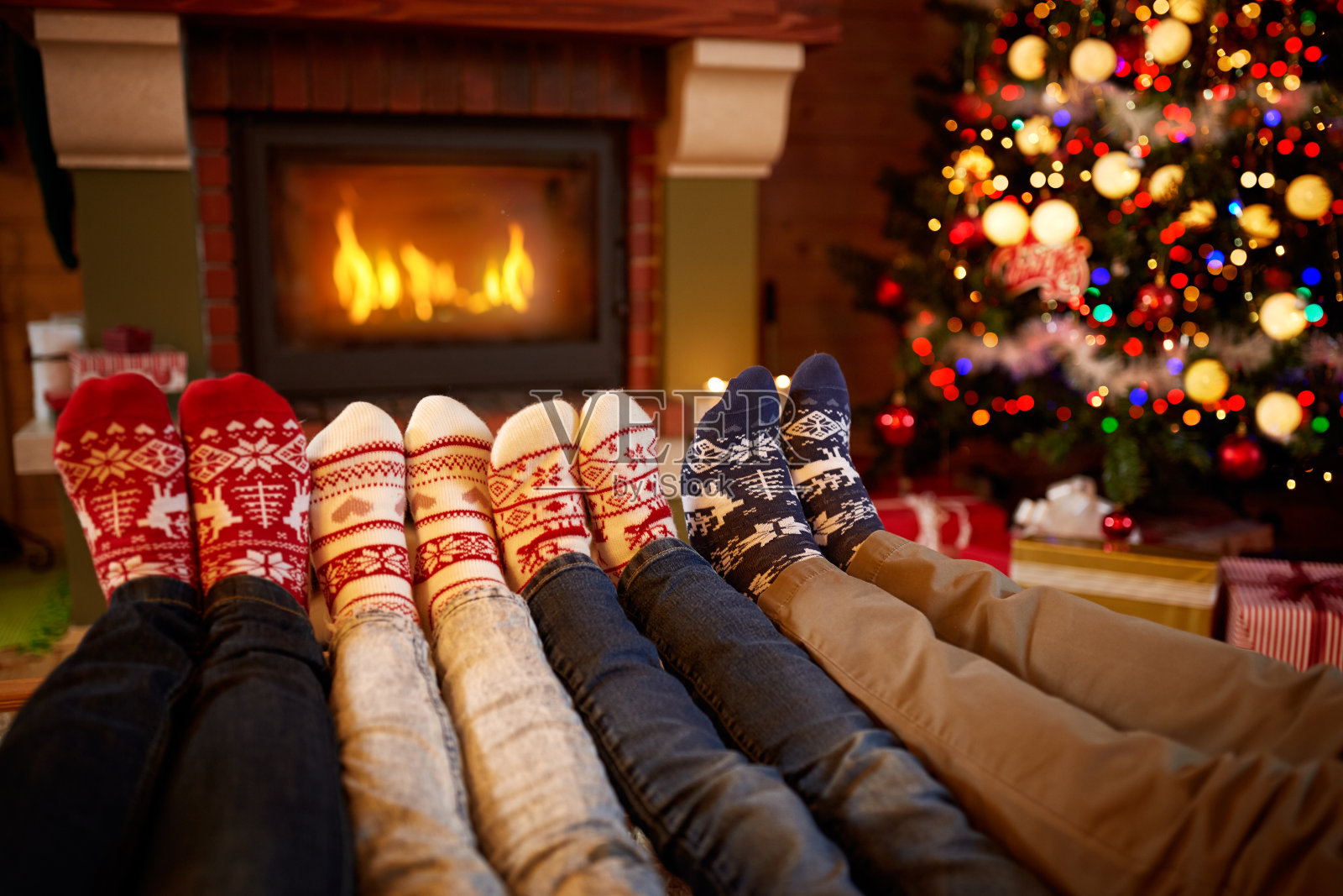 穿着羊毛袜子的脚在圣诞节时靠近壁炉照片摄影图片