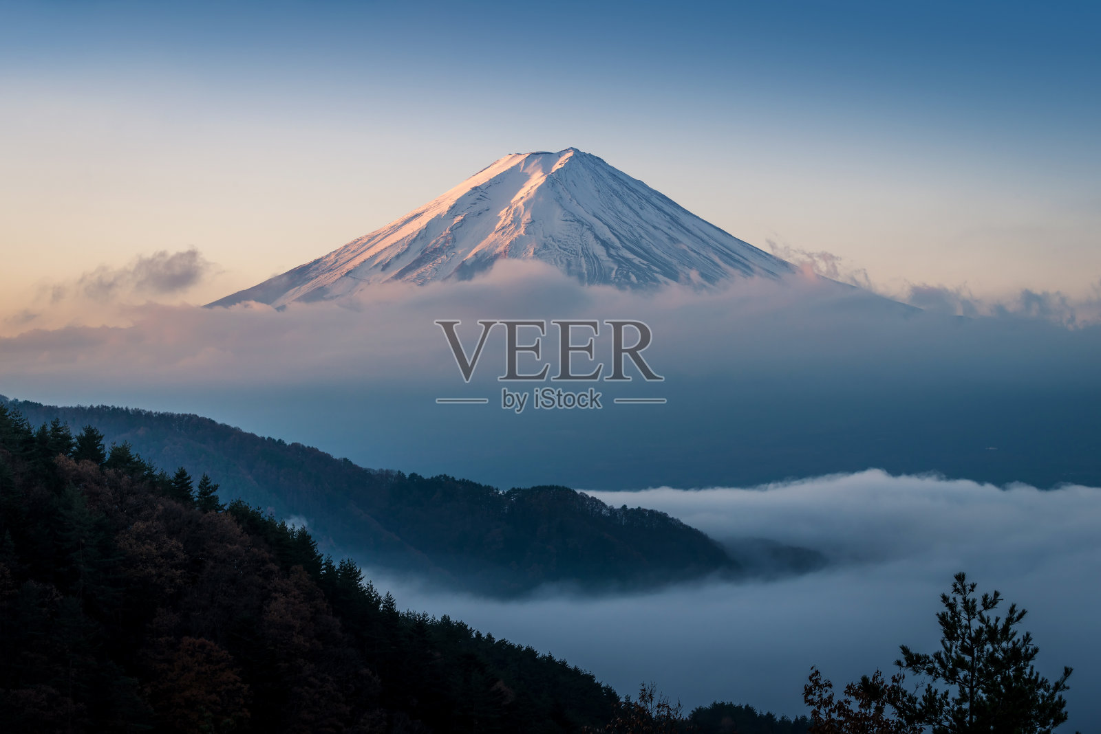 富士山笼罩在云中，天空晴朗照片摄影图片