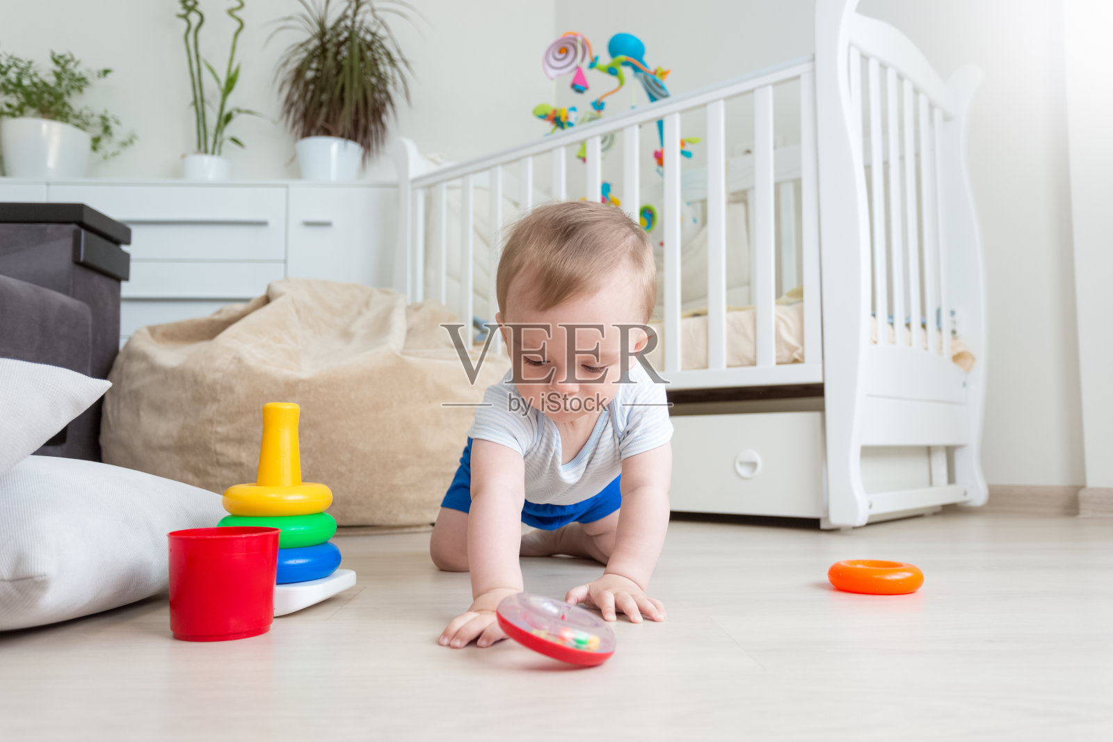 婴儿在地板上玩玩具塔上五颜六色的环照片摄影图片