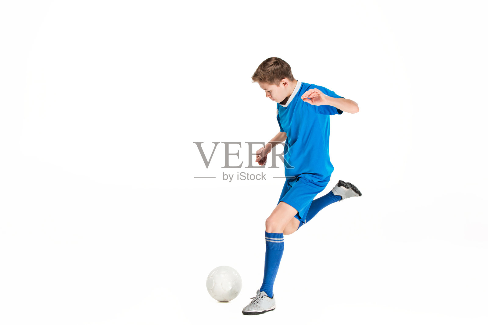 小男孩踢着足球飞踢照片摄影图片