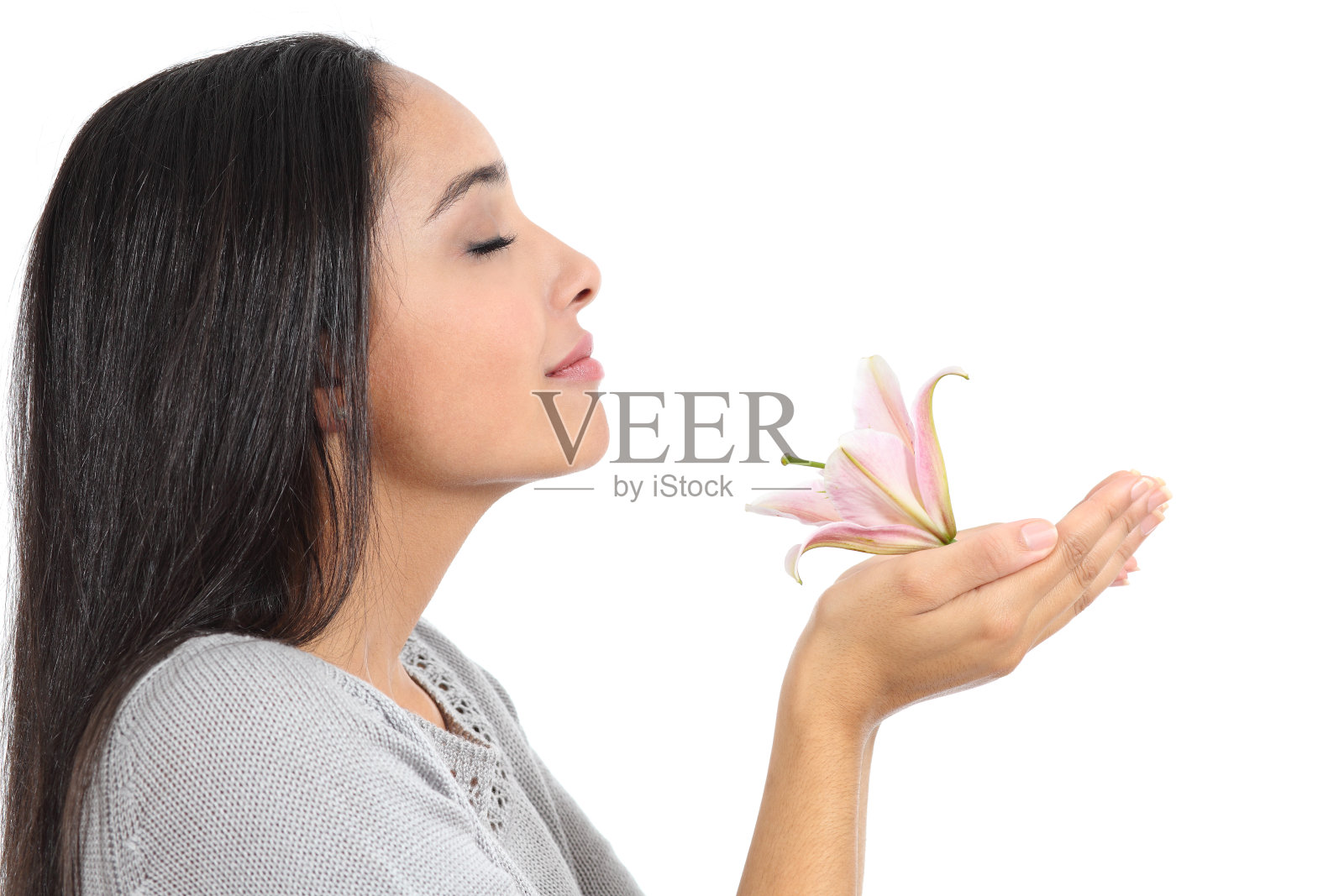 一个阿拉伯女人闻着花香的侧视图照片摄影图片