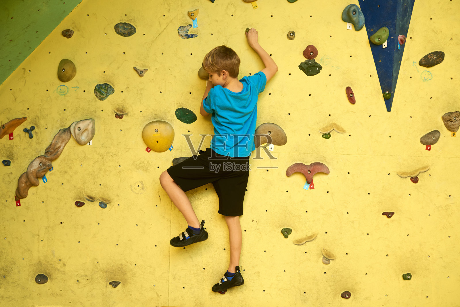 自由攀岩的小男孩在人造巨石上练习照片摄影图片