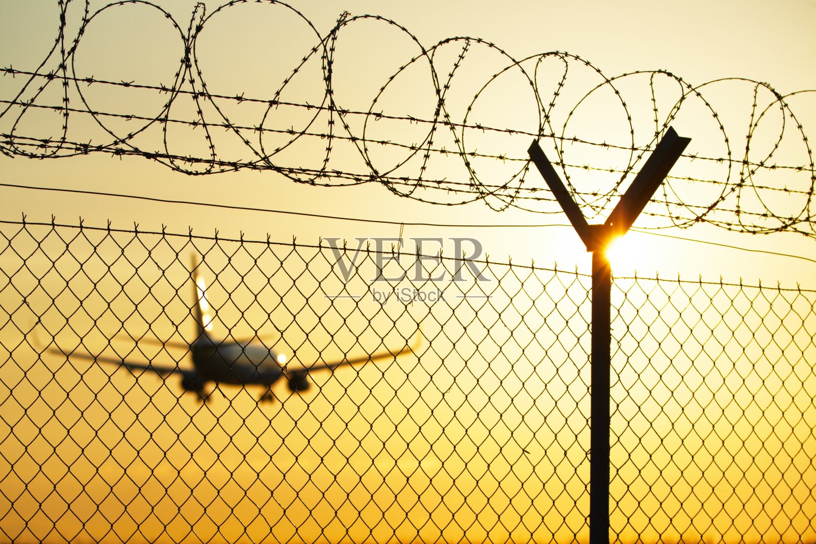 日落时分的机场警卫围栏后照片摄影图片