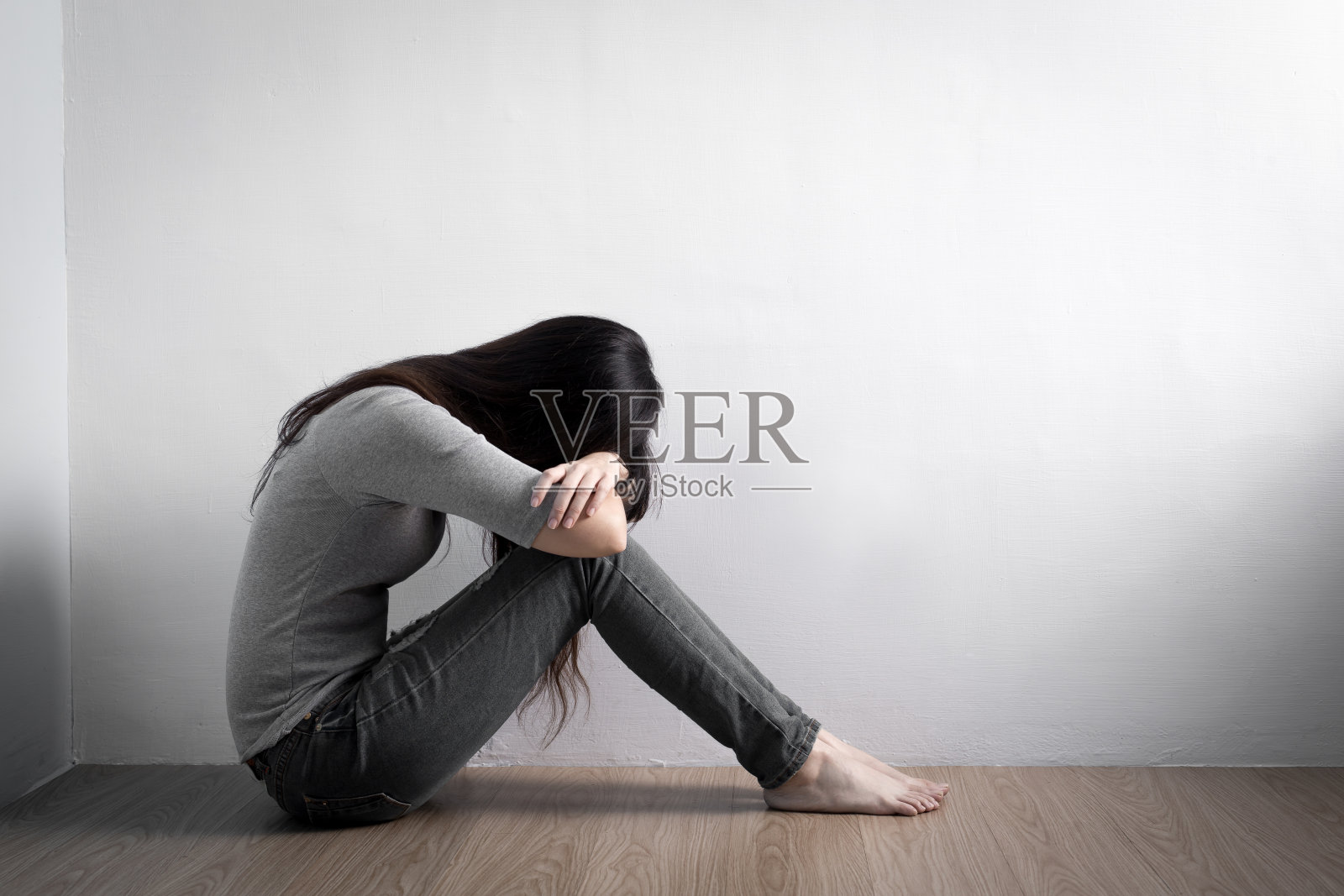 抑郁的女人坐在地板上照片摄影图片