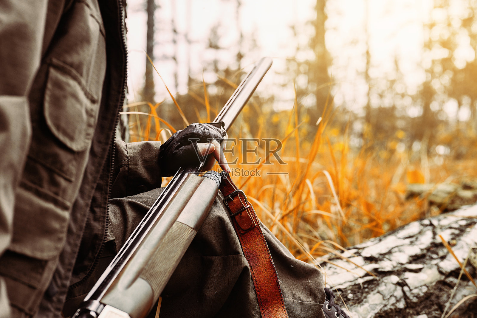 拿着枪的女猎人。在树林里打猎。照片摄影图片