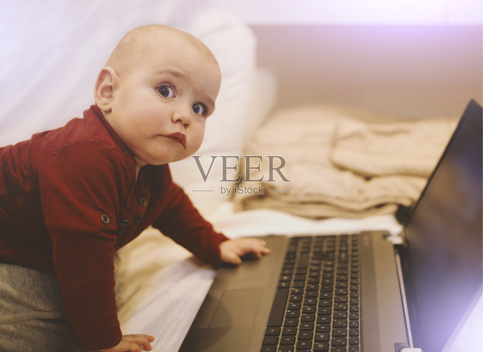 婴儿使用的笔记本电脑。IT行业是他的未来。照片摄影图片