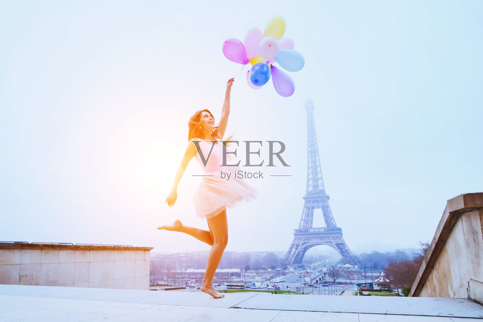 拿着气球的女孩在巴黎埃菲尔铁塔附近跳照片摄影图片