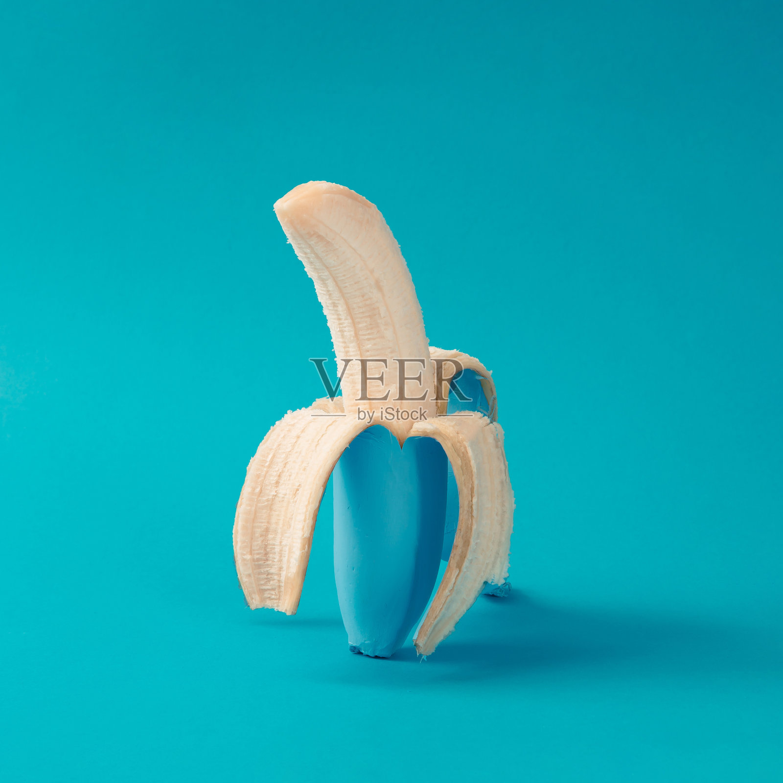 涂成蓝色去皮的香蕉。最小的概念。照片摄影图片