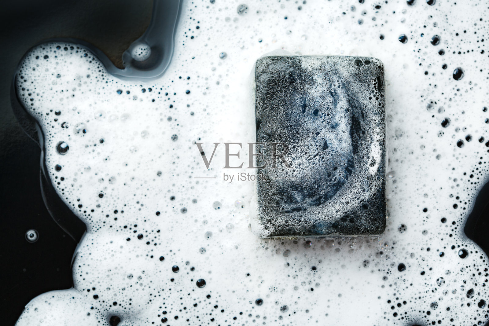 黑煤棒上的肥皂在泡沫上发黑照片摄影图片