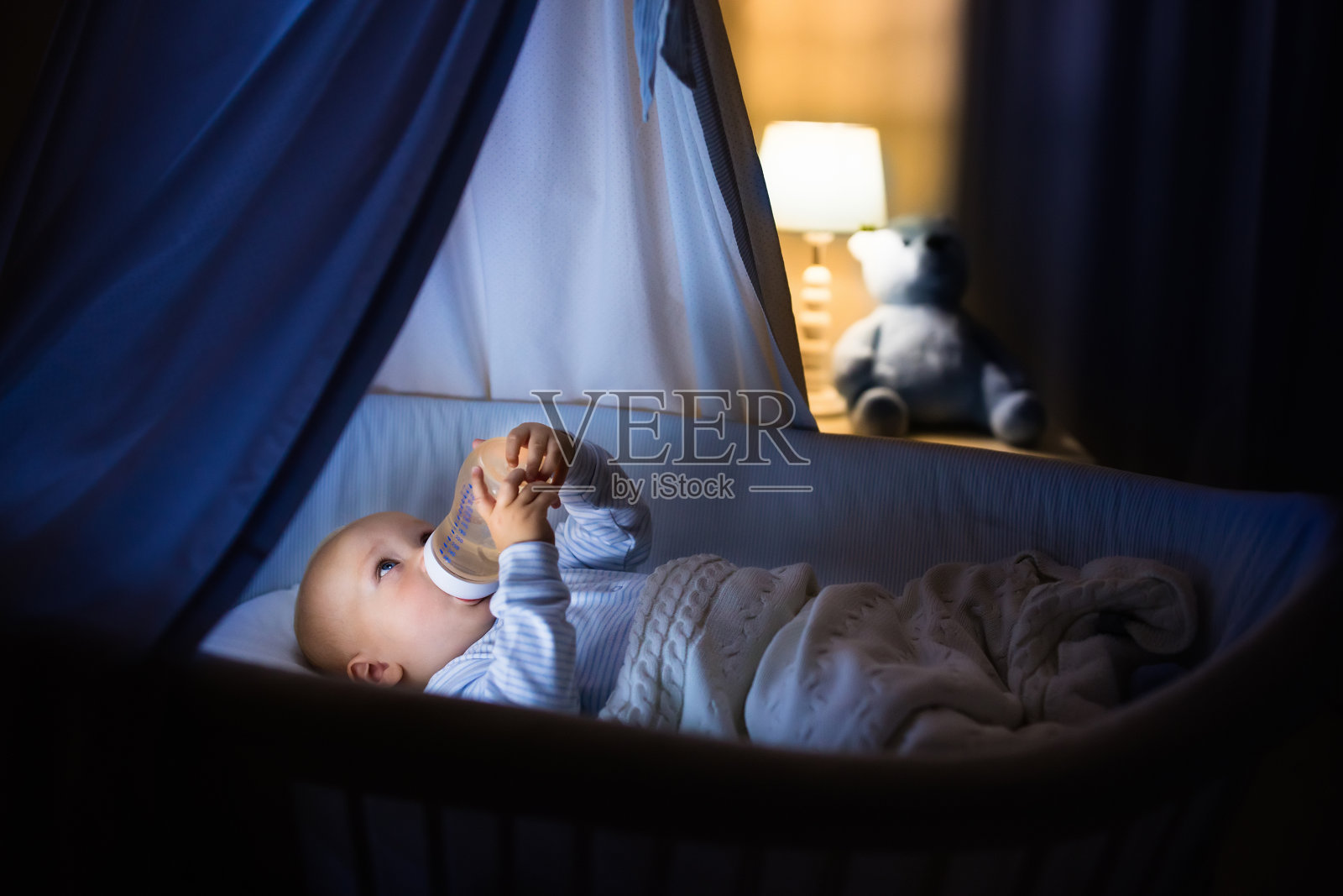 小男孩在床上喝牛奶照片摄影图片