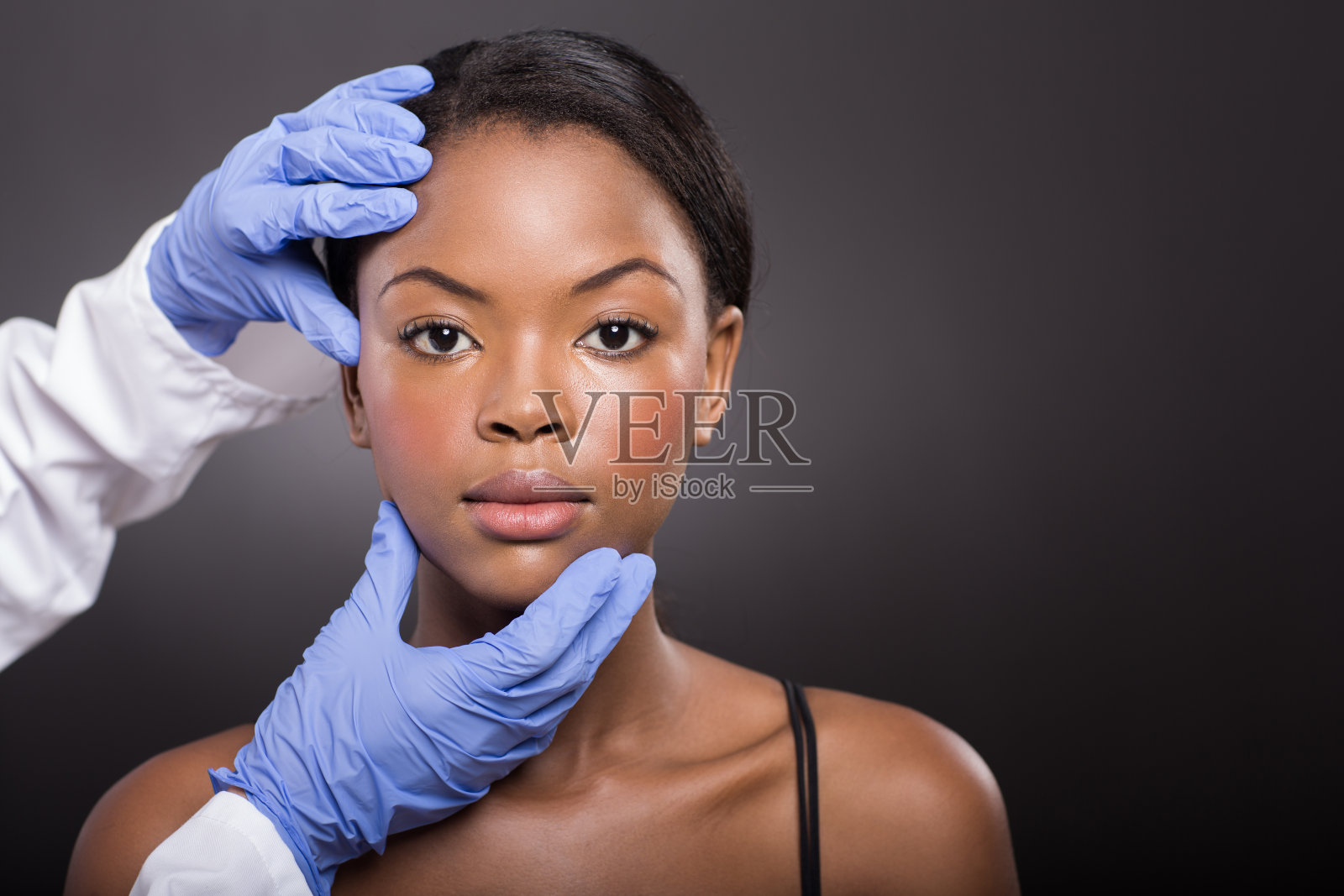 皮肤科医生检查非洲女性面部皮肤照片摄影图片