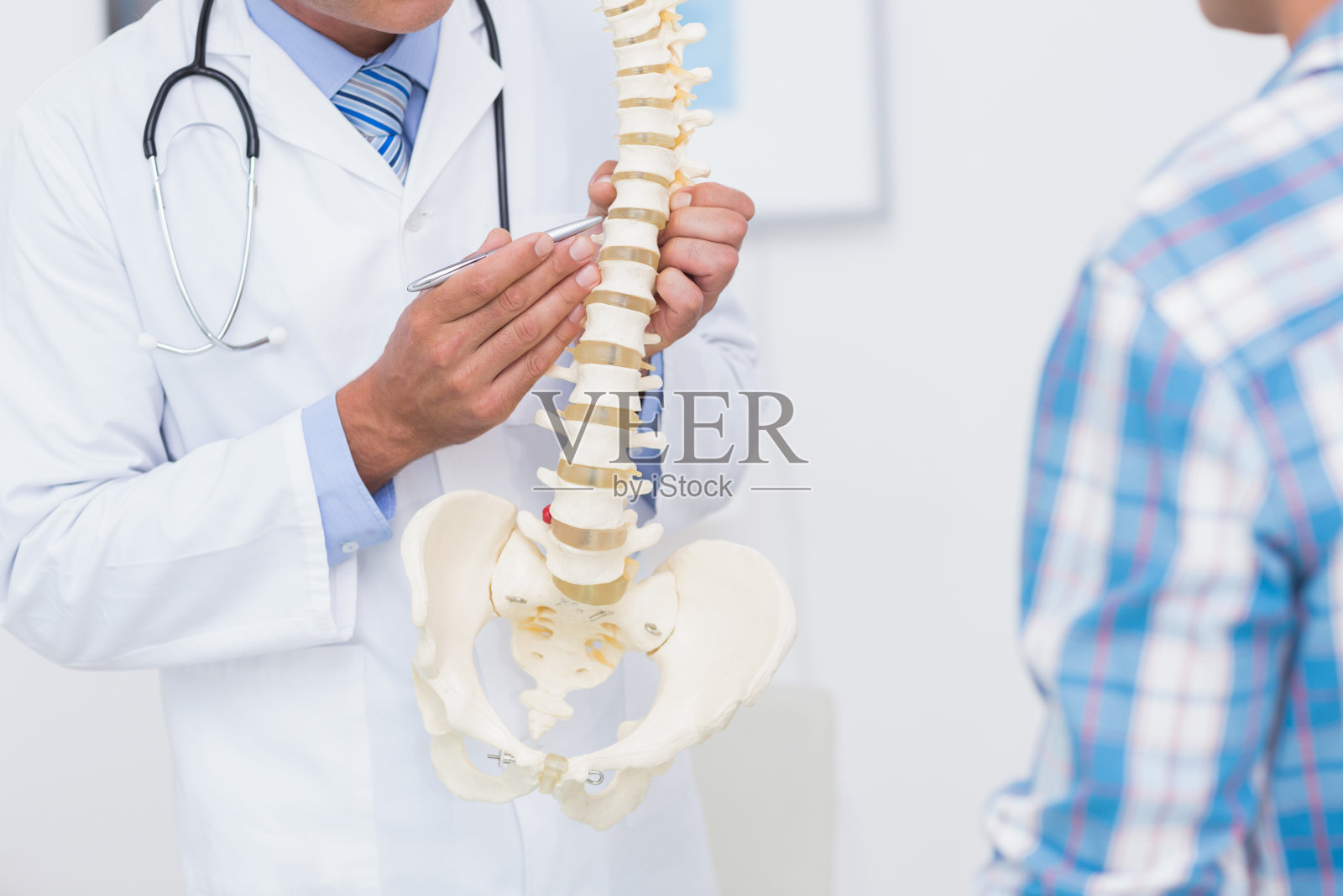 医生给病人看解剖脊柱照片摄影图片
