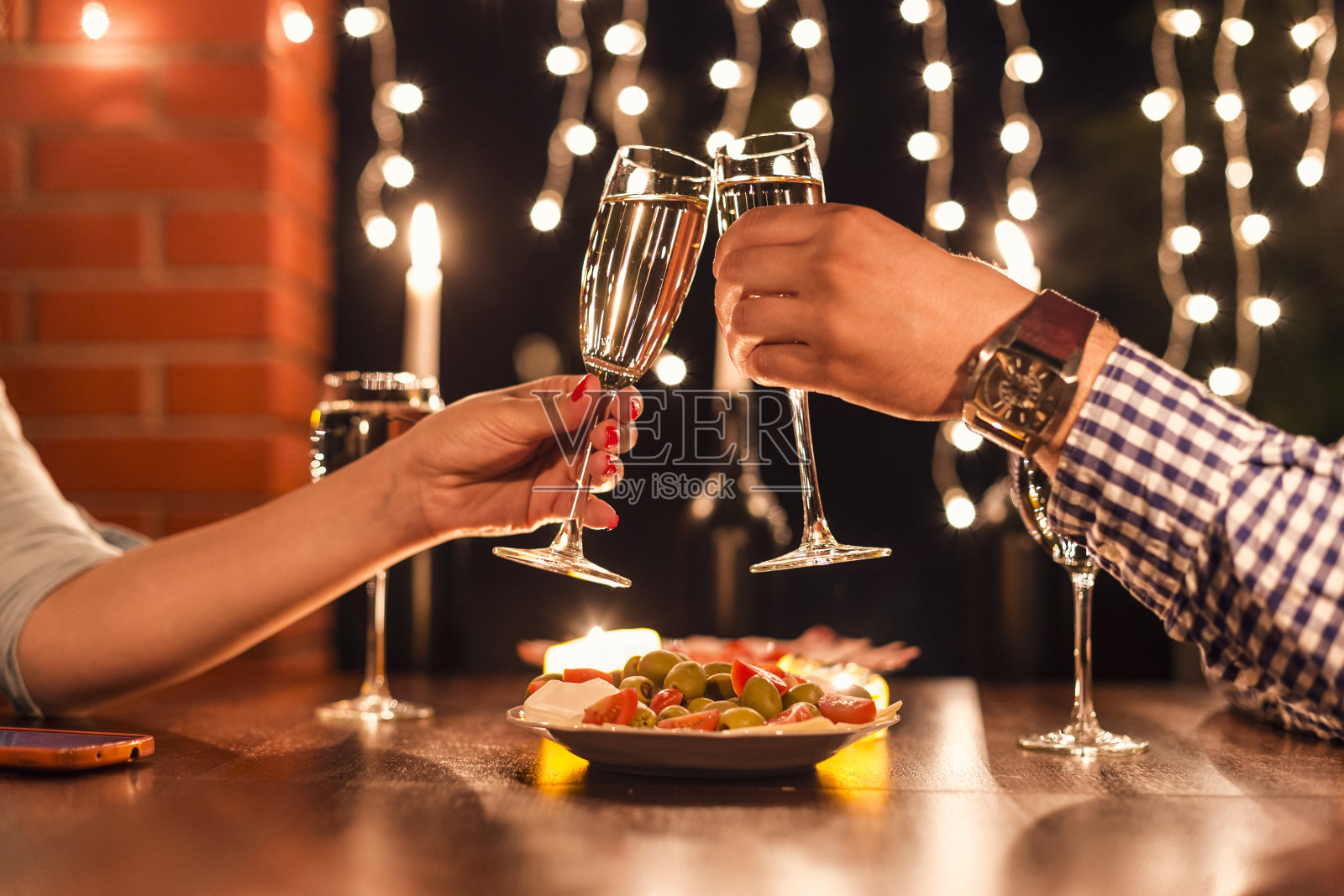 一对年轻夫妇在烛光下享受浪漫晚餐。照片摄影图片