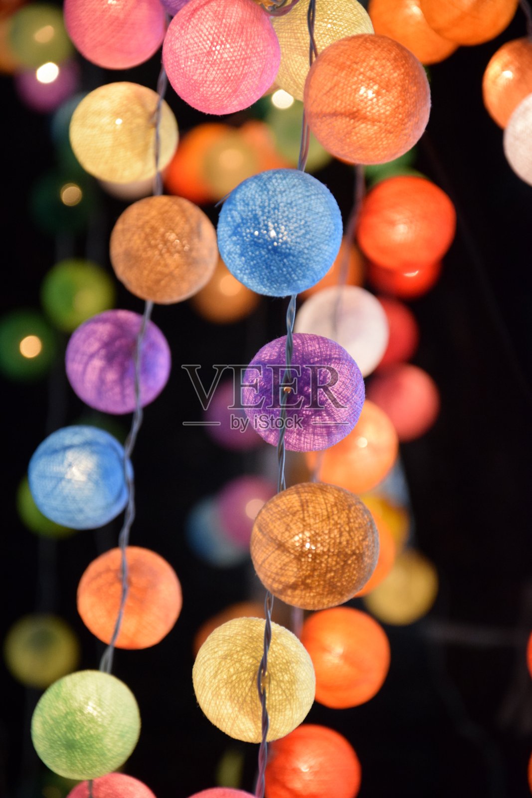 一个泰国家庭装饰的特写:几个不同颜色的纱线灯球。温暖、欢乐、幸福的感觉。模糊的背景。照片摄影图片