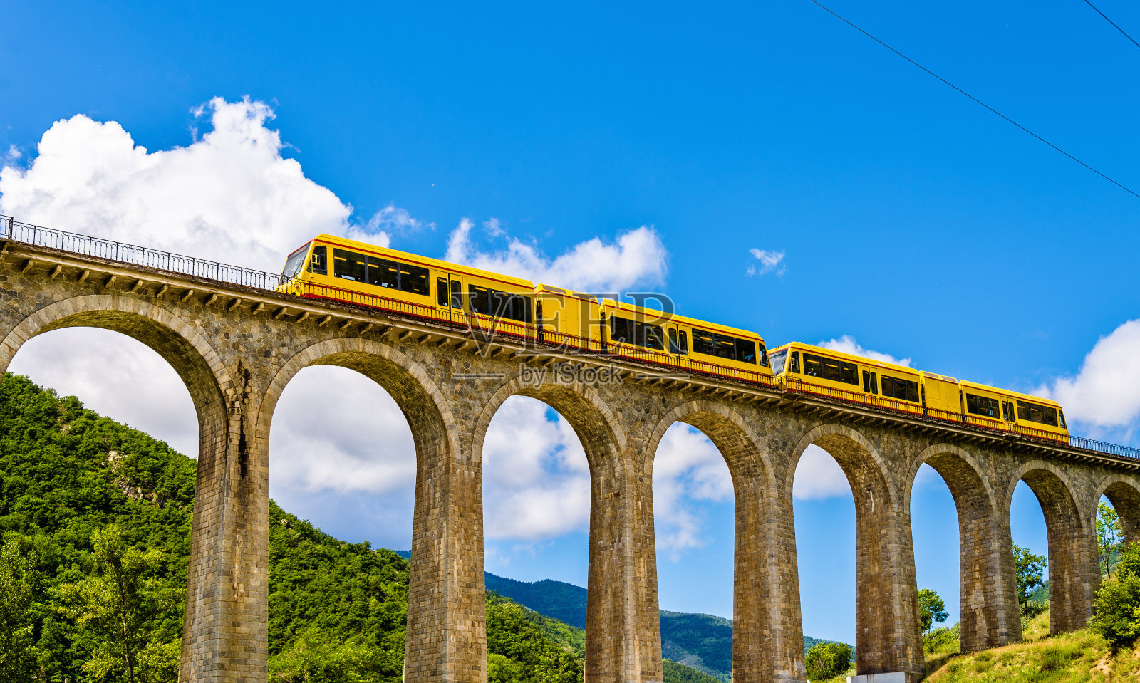 在Sejourne桥上的黄色火车照片摄影图片