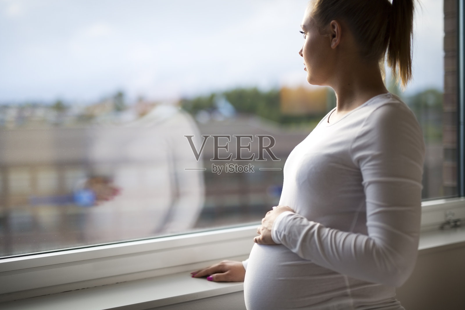 体贴的孕妇看着窗外照片摄影图片