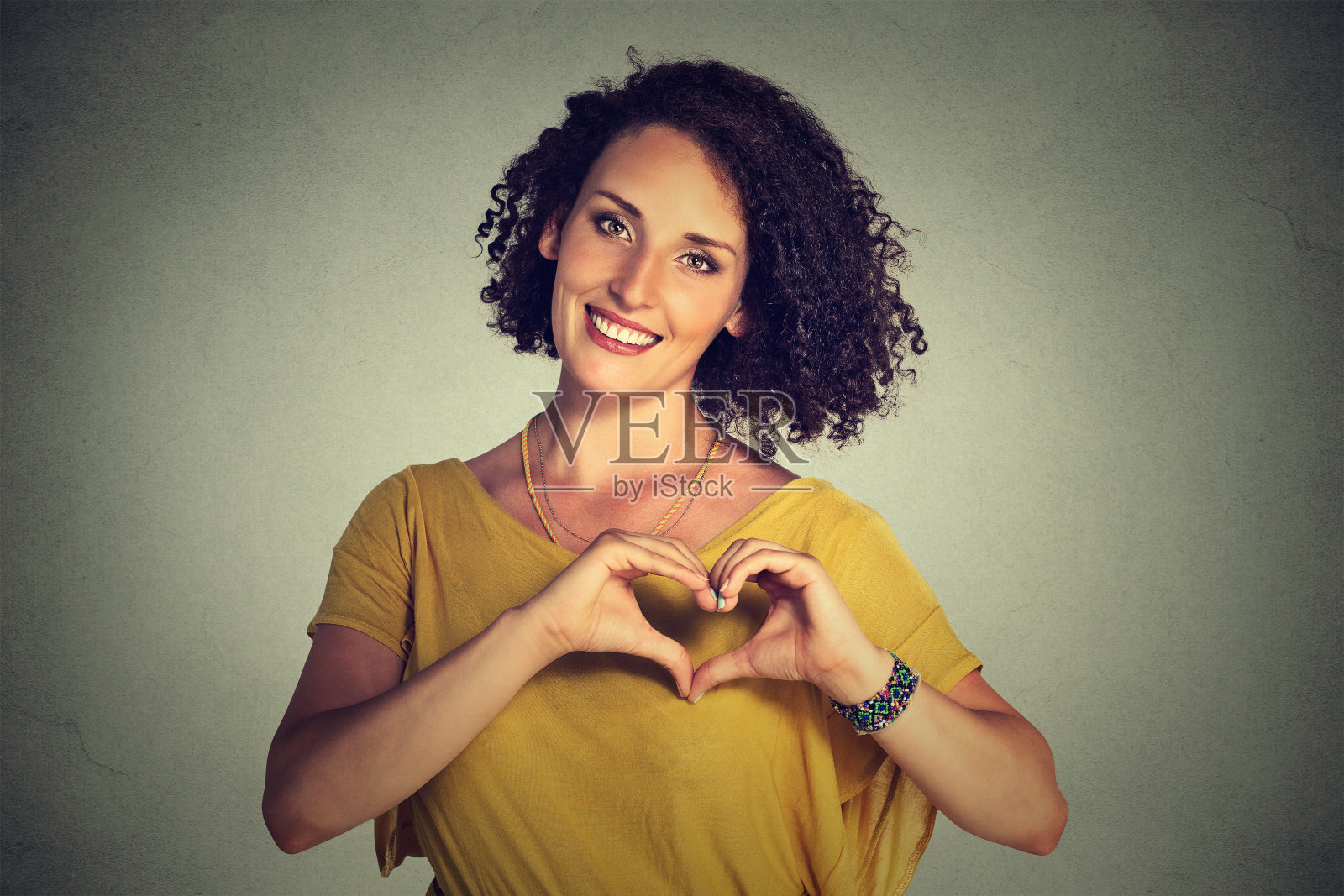 微笑的快乐的女人用手做心的手势照片摄影图片