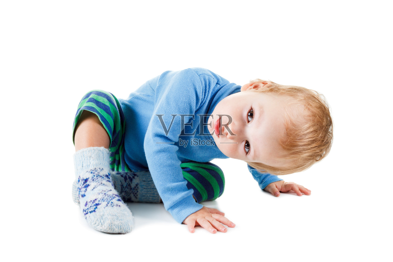 可爱的金发宝宝穿着蓝色的毛衣在白色的衣服上玩耍照片摄影图片