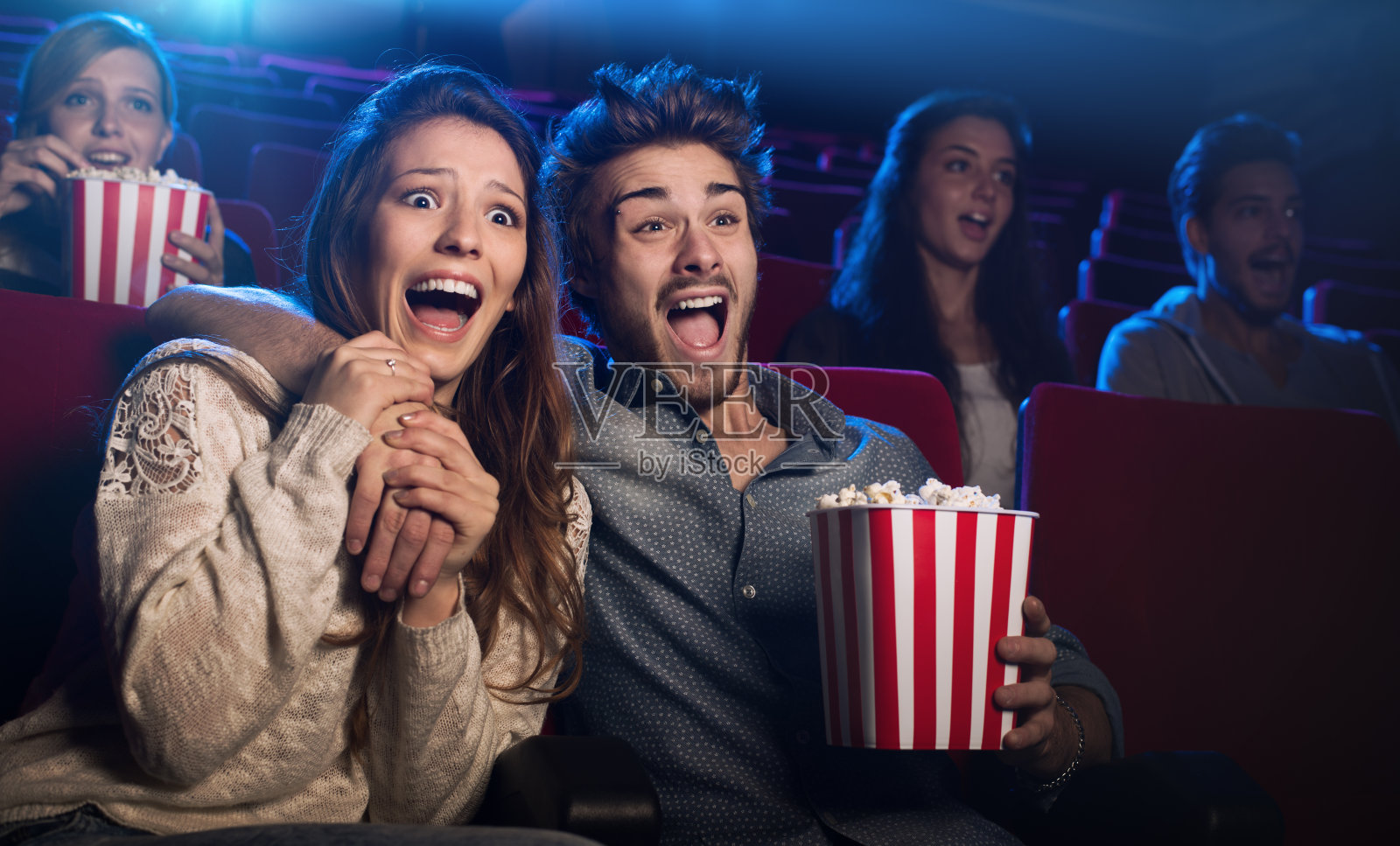 一对年轻夫妇在电影院看恐怖电影照片摄影图片