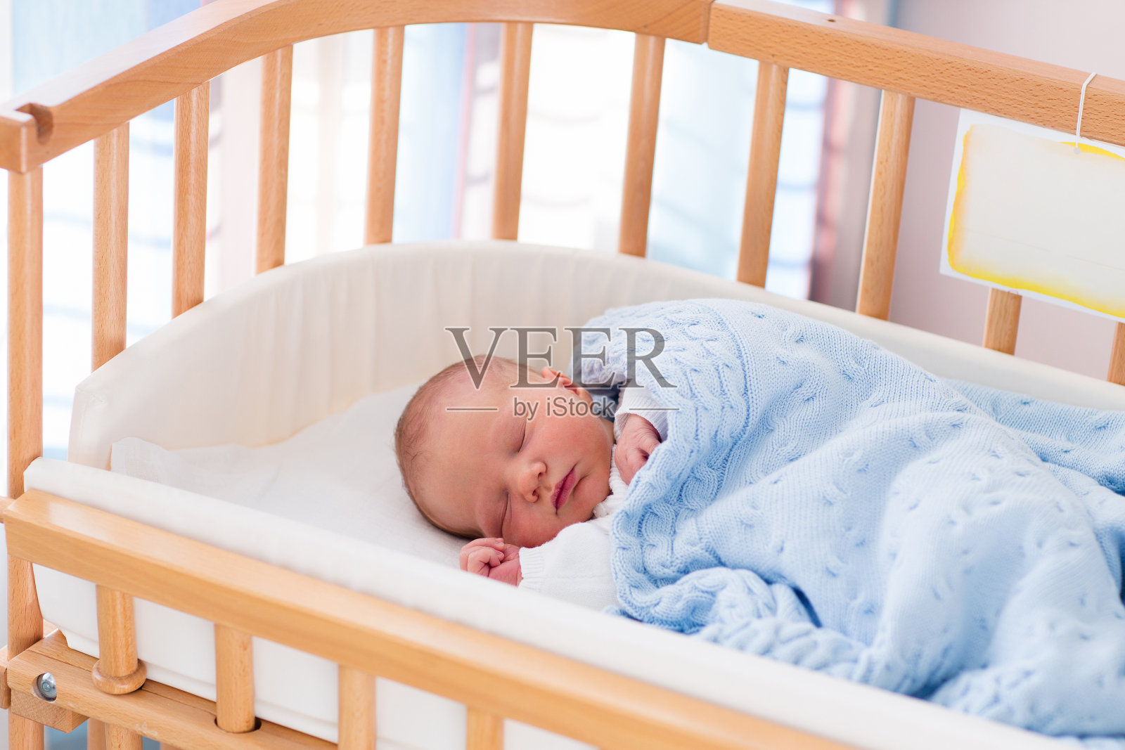 刚出生的男婴躺在医院的婴儿床上照片摄影图片