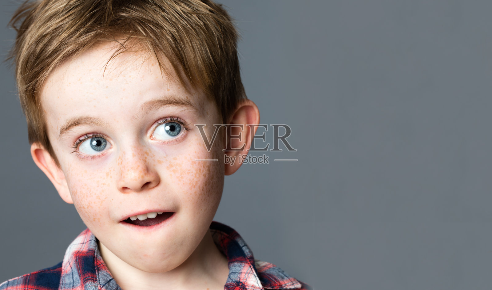 漂亮的红头发，满脸雀斑的学龄前儿童仰头做白日梦照片摄影图片