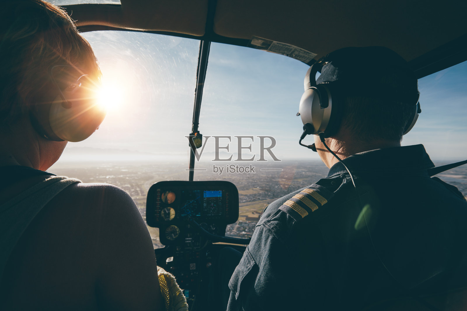 两个飞行员在一个阳光明媚的日子里驾驶直升机照片摄影图片
