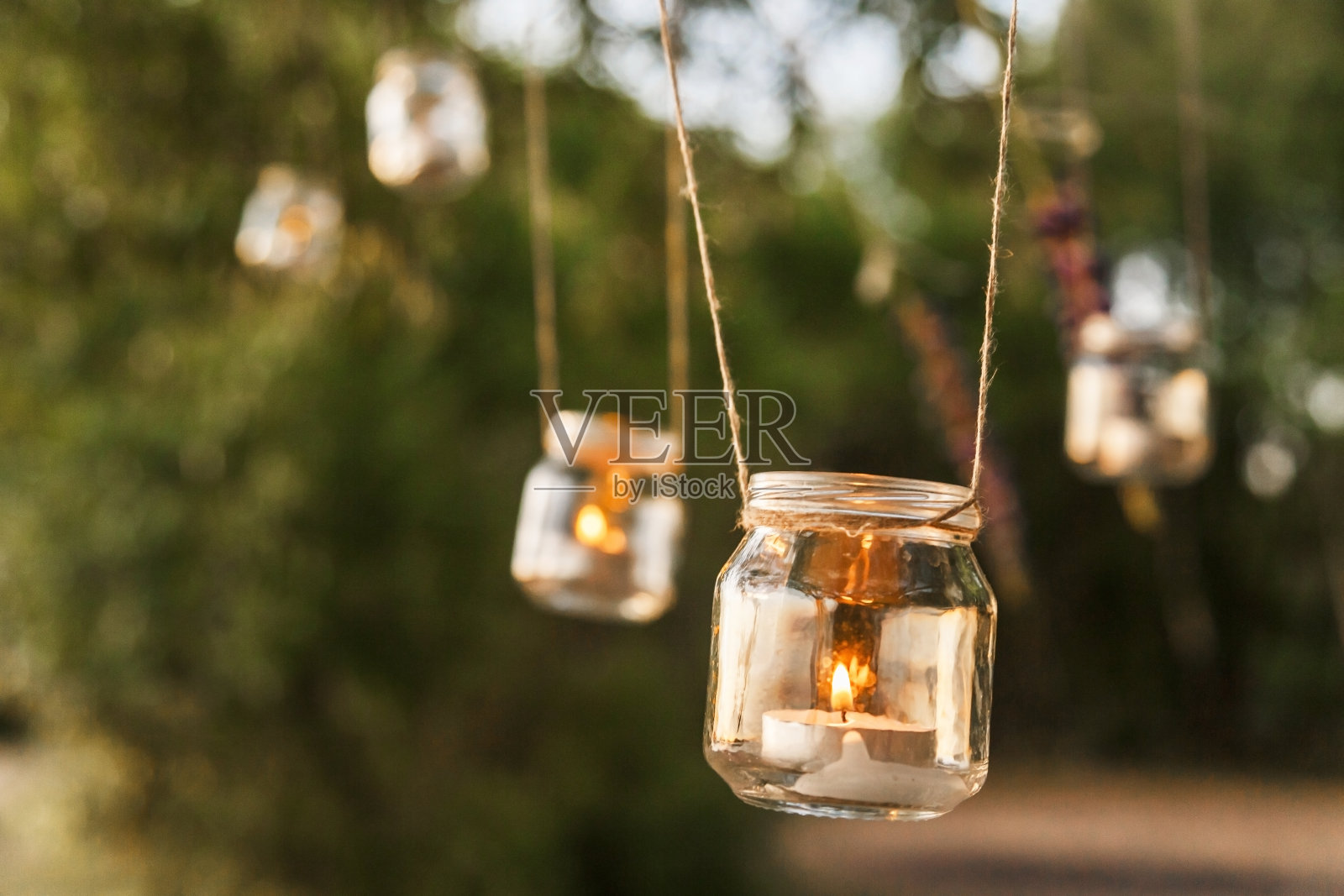 在圣诞树上悬挂的玻璃罐蜡烛作为婚礼装饰照片摄影图片