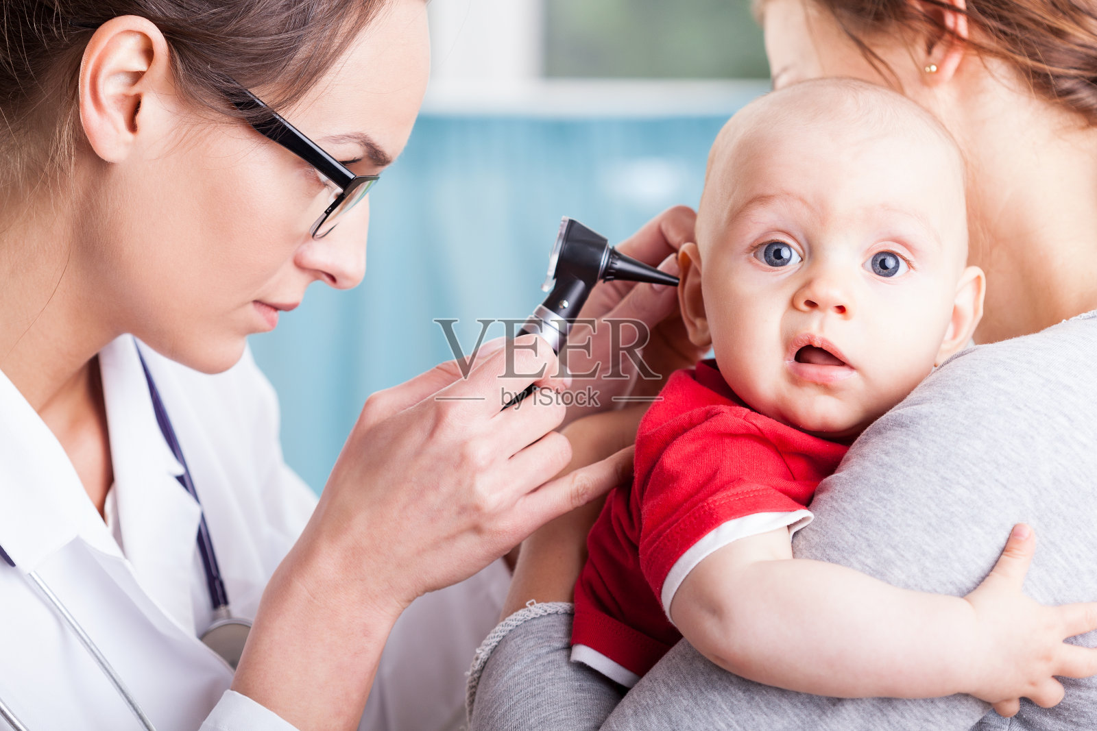 医生用耳镜检查男婴照片摄影图片