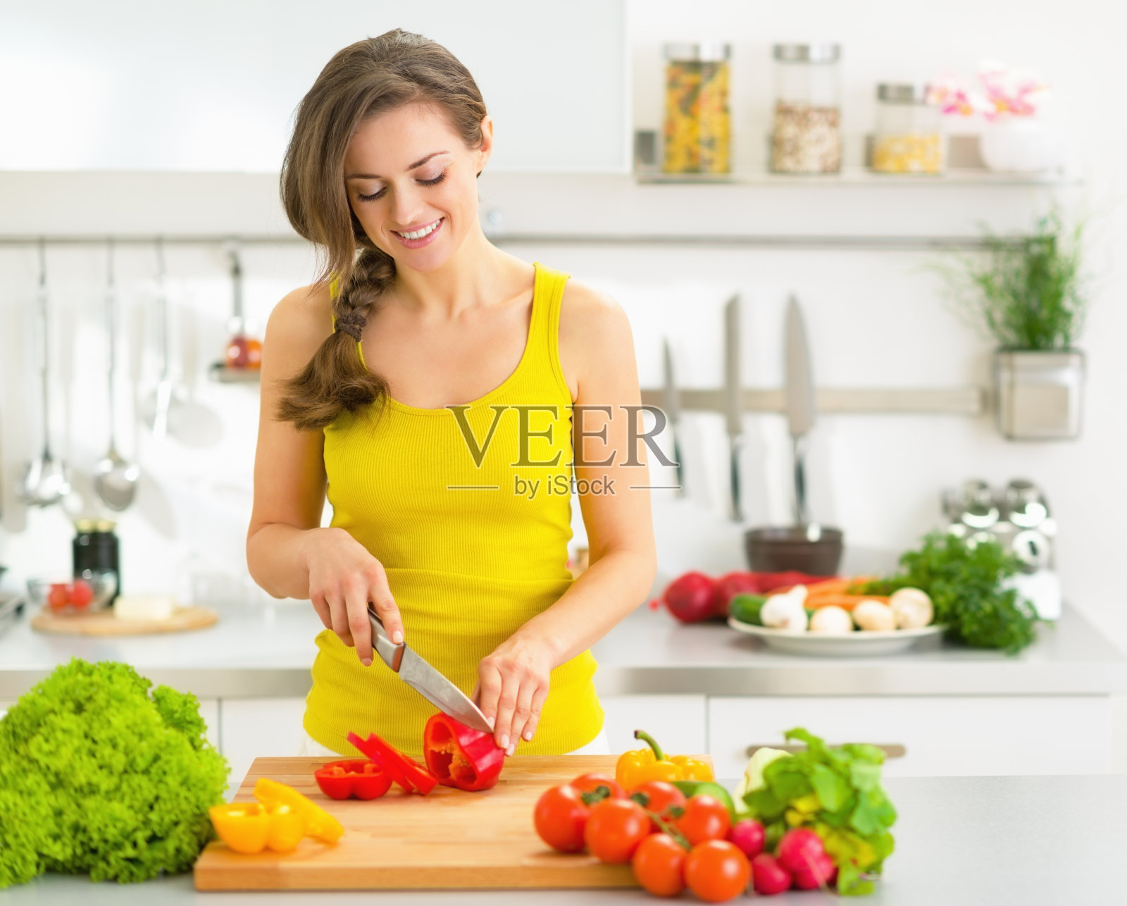 快乐的年轻女子在厨房切新鲜蔬菜照片摄影图片