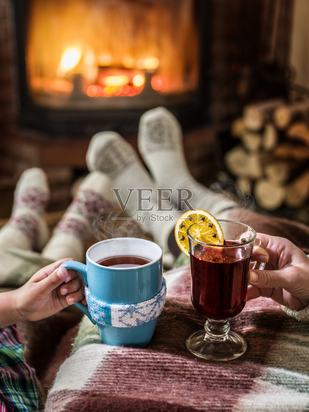 在壁炉旁放松，喝一杯热饮。照片摄影图片