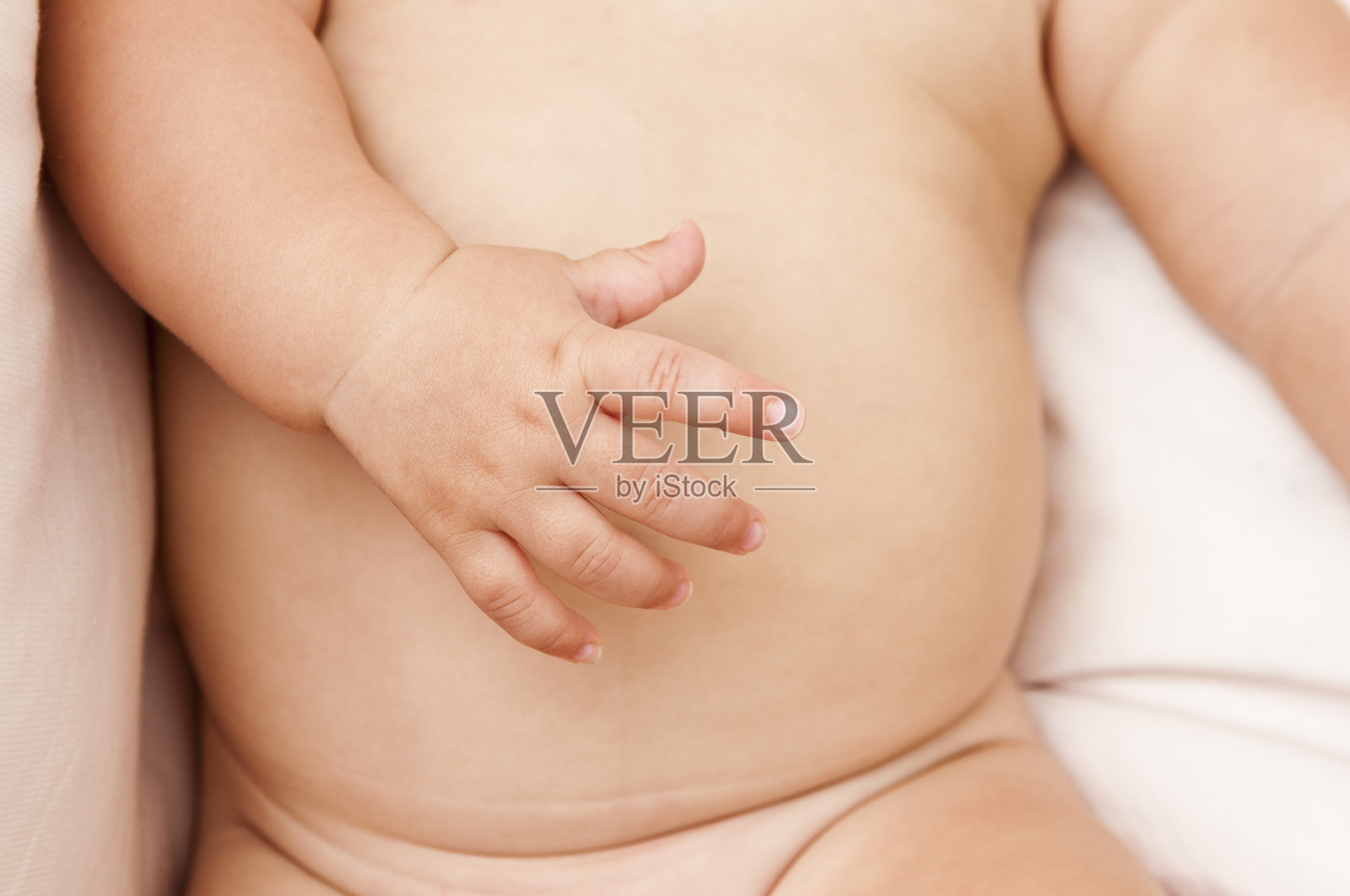 可爱的手在一个小婴儿的肚子照片摄影图片