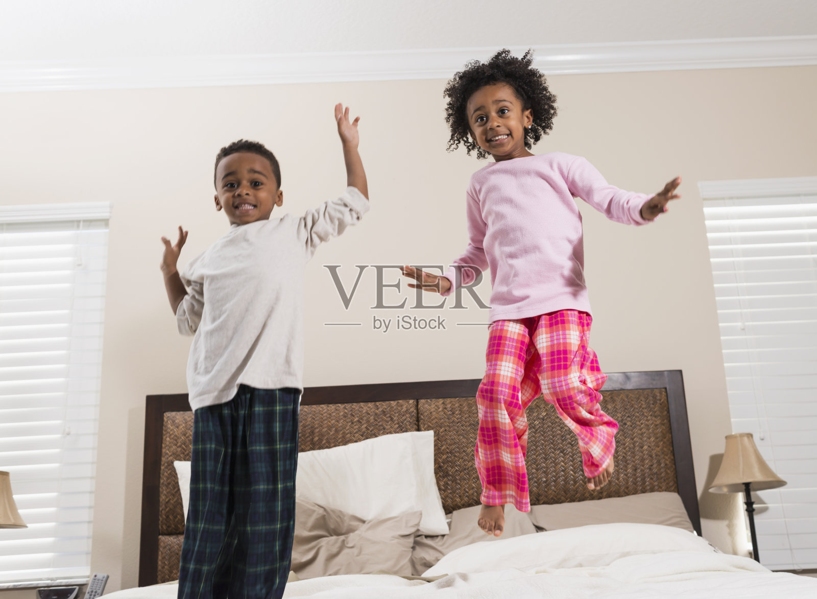 非裔美国儿童在床上跳得很开心照片摄影图片