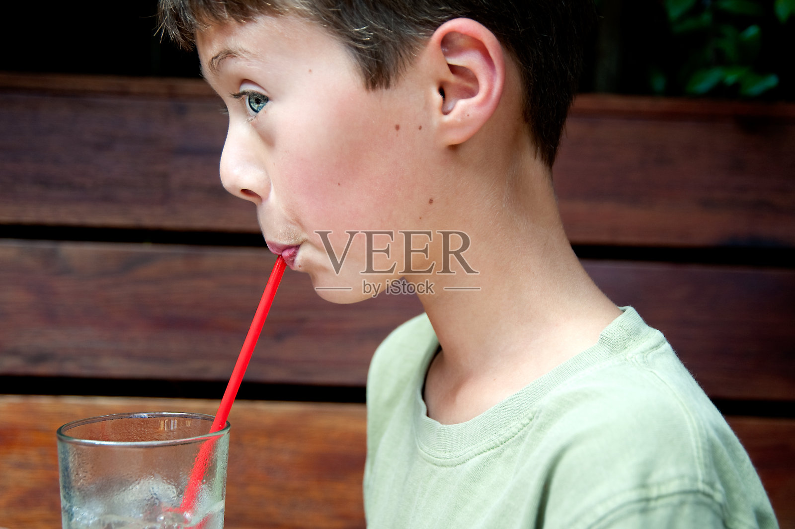 用吸管喝水的男孩照片摄影图片