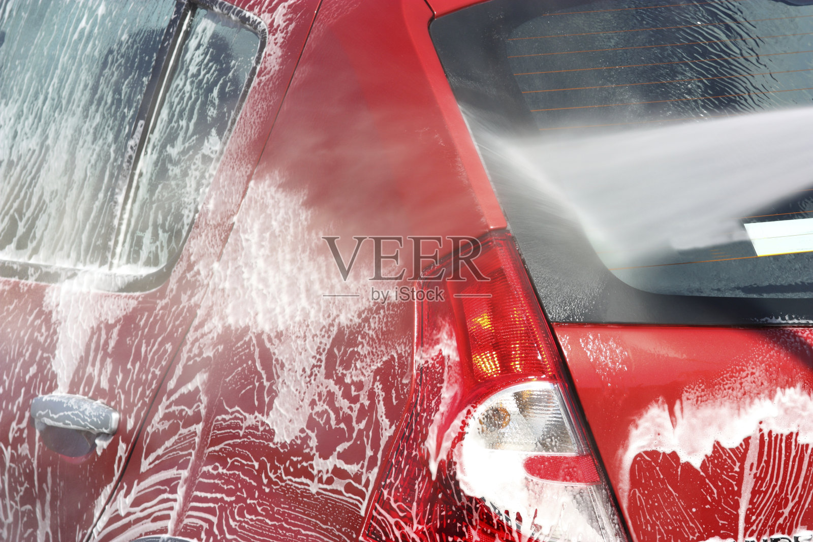 一辆正在用肥皂洗车的红色汽车照片摄影图片