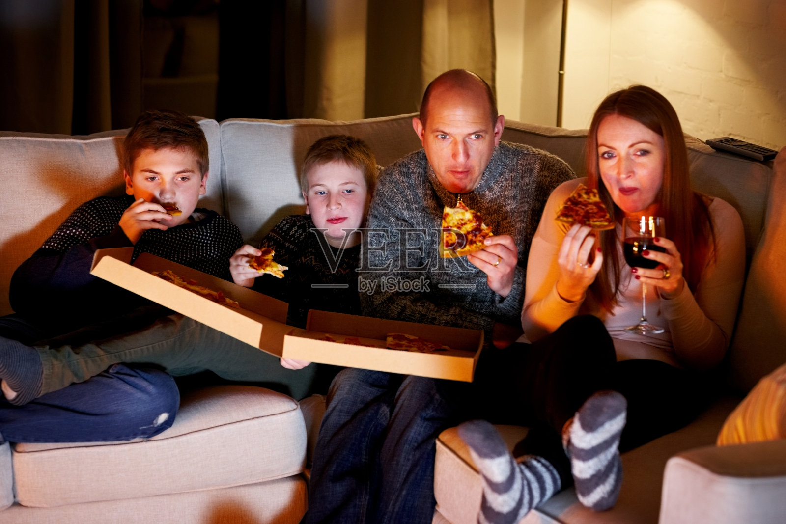 全家一起吃披萨看电视照片摄影图片