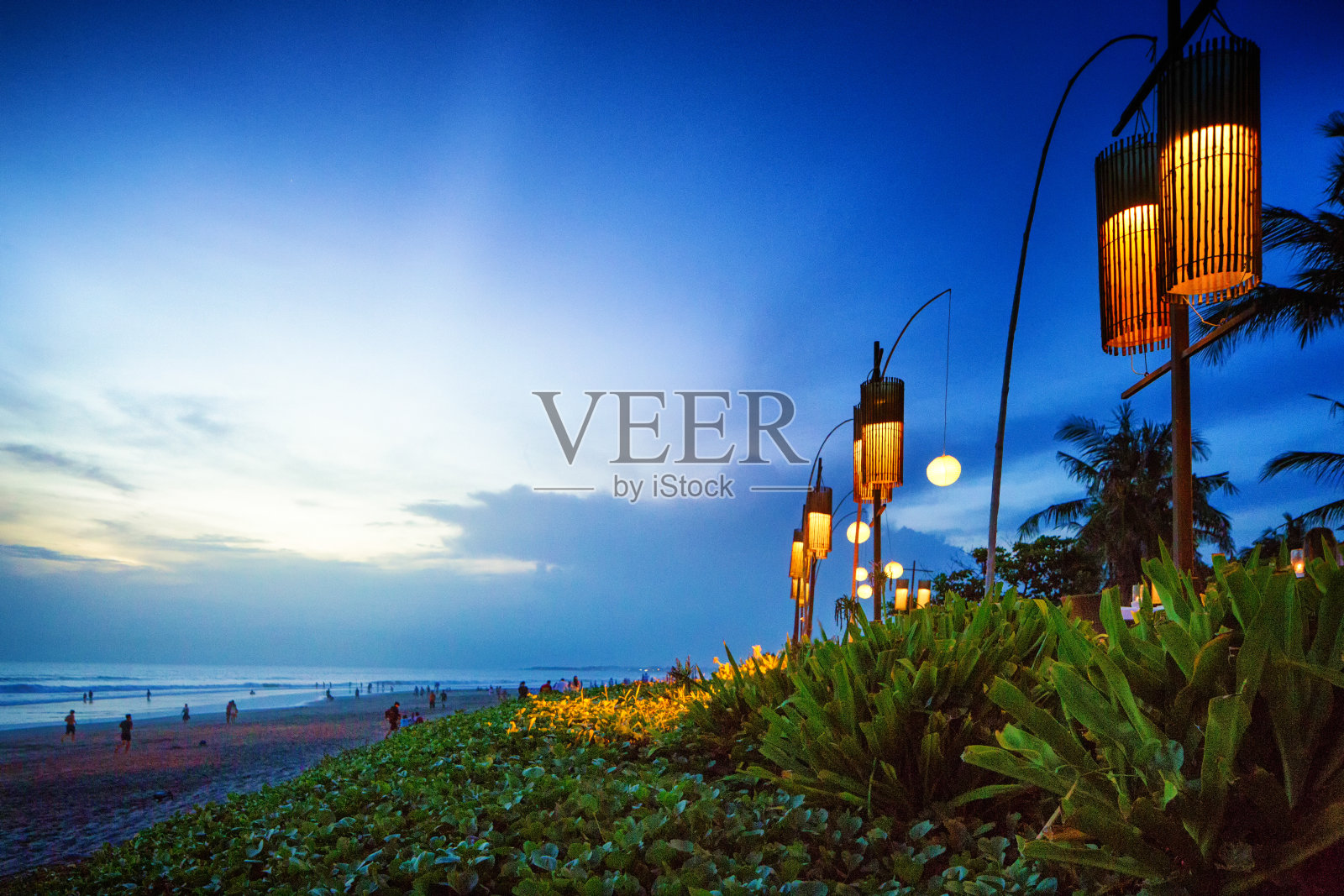 日落时印度尼西亚巴厘岛丹巴萨水明漾海滩上的灯笼照片摄影图片