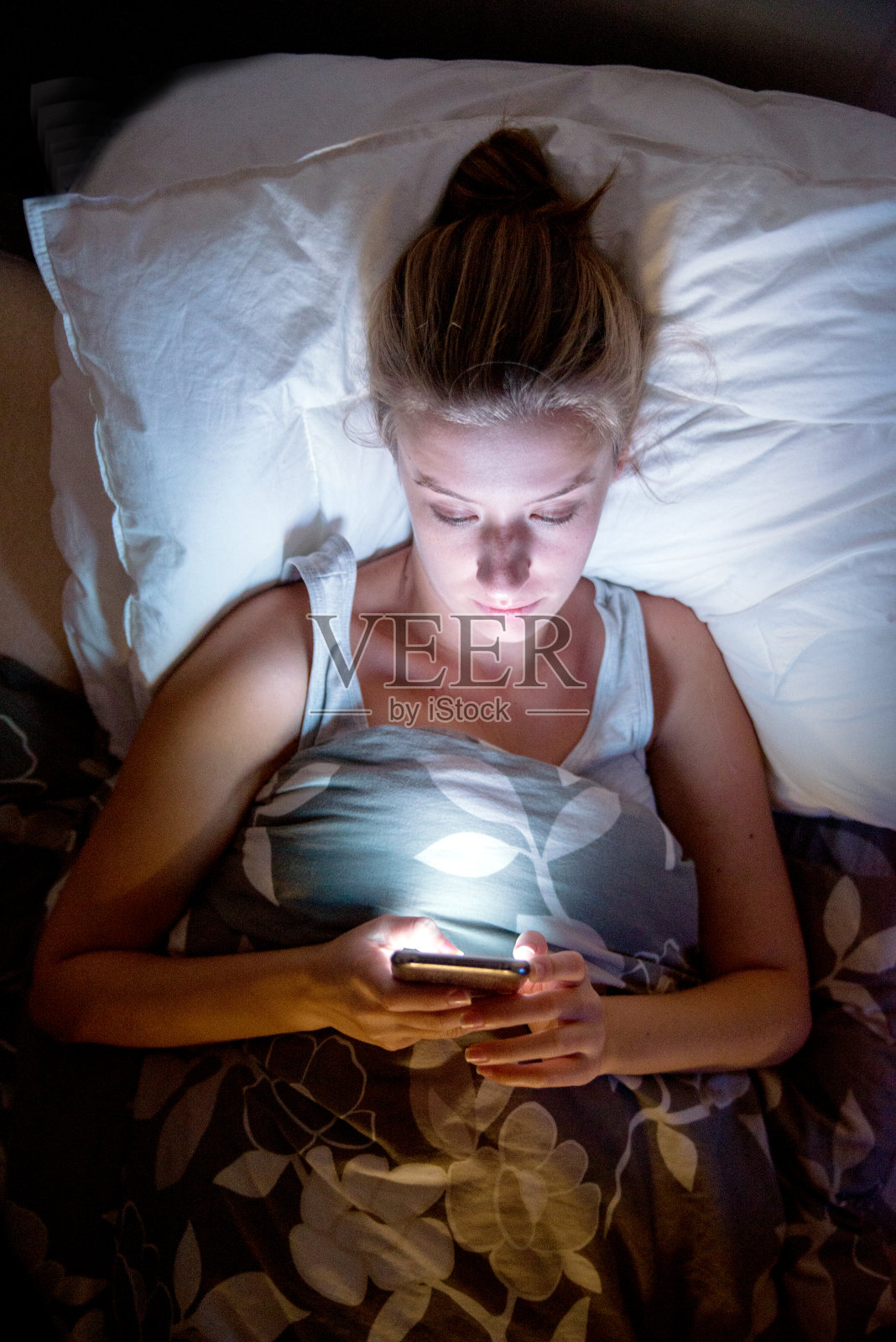 女人躺在床上，压力，焦虑，孤独地发短信照片摄影图片