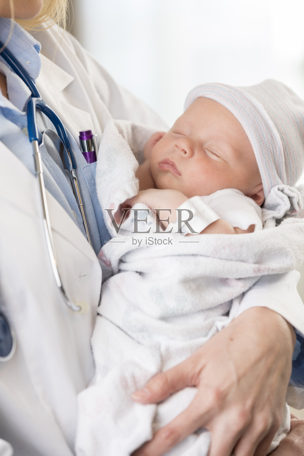 女儿科医生抱着熟睡的女婴照片摄影图片
