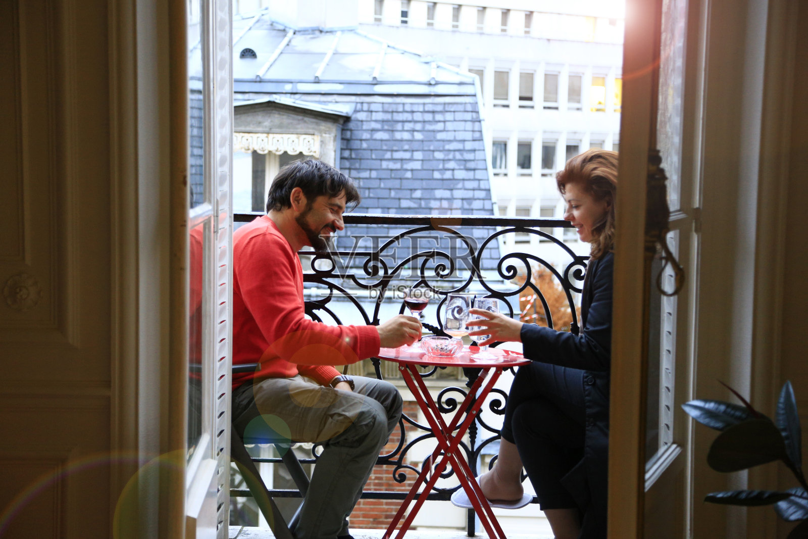 一对情侣在巴黎的阳台上喝酒照片摄影图片