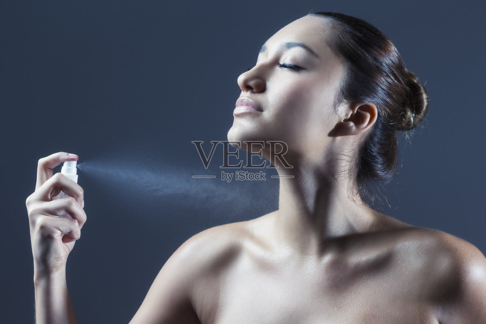 性感年轻的西班牙女人用香水喷自己照片摄影图片