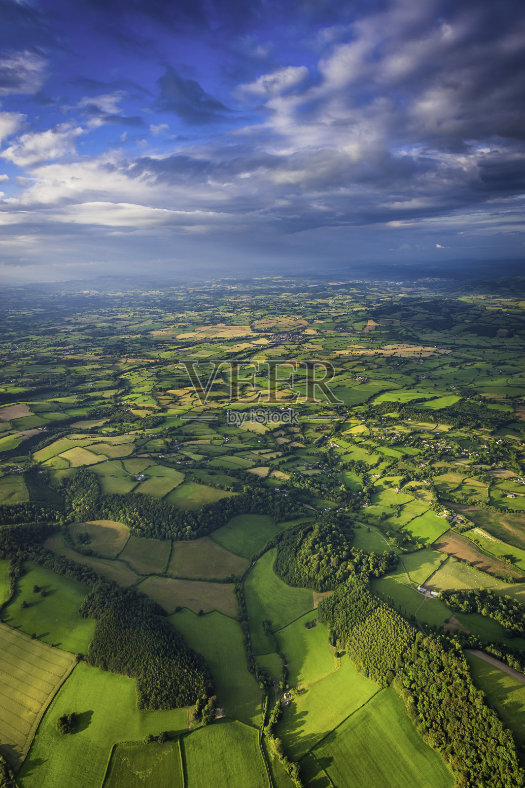 在广阔的乡村天空下，从空中俯瞰夏天绿色的景色照片摄影图片