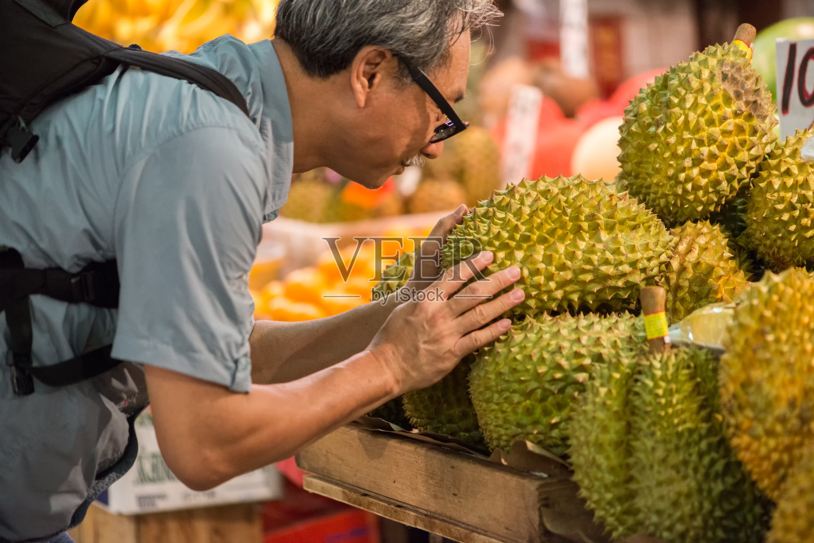 一名亚洲男子在市场上检验榴莲照片摄影图片