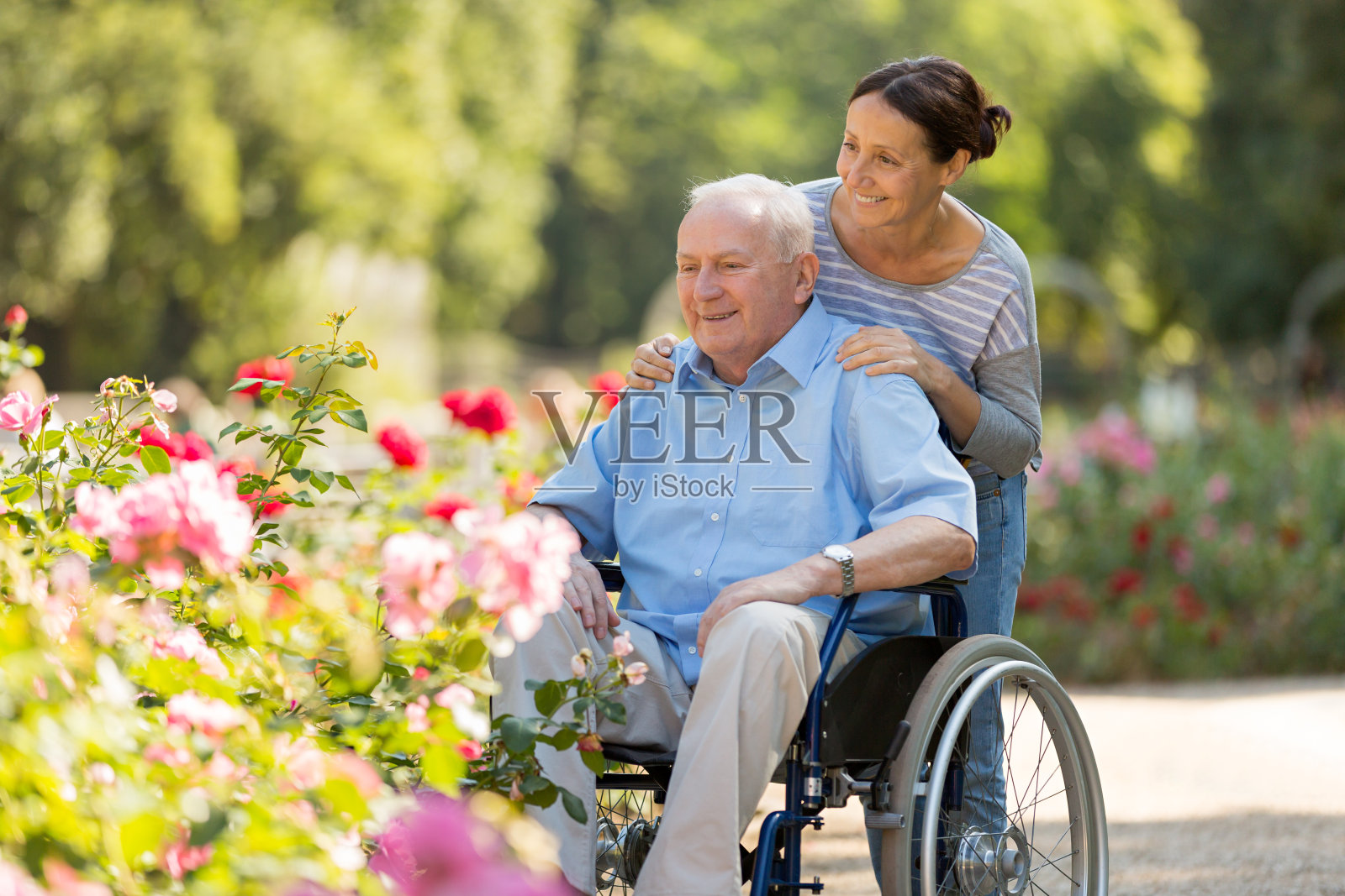 老人和护工坐在轮椅上照片摄影图片